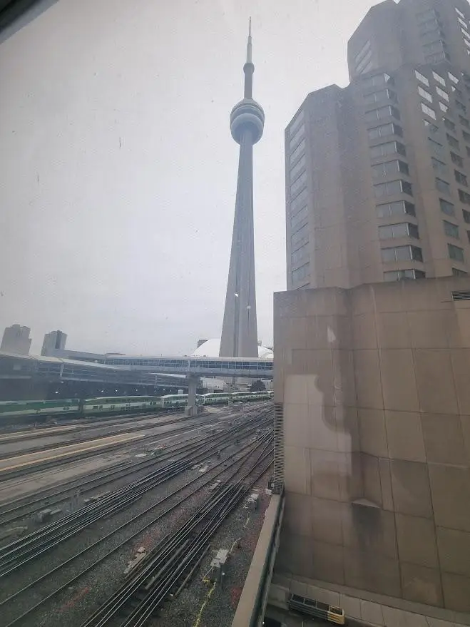 CN Tower Toronto photographed from railway tracks – urban architecture and skyline by Daniel Wisniewski.