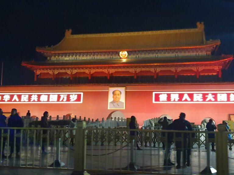 Night view of Tiananmen Gate in Beijing, with its traditional roof, red walls and portrait of Mao Zedong.